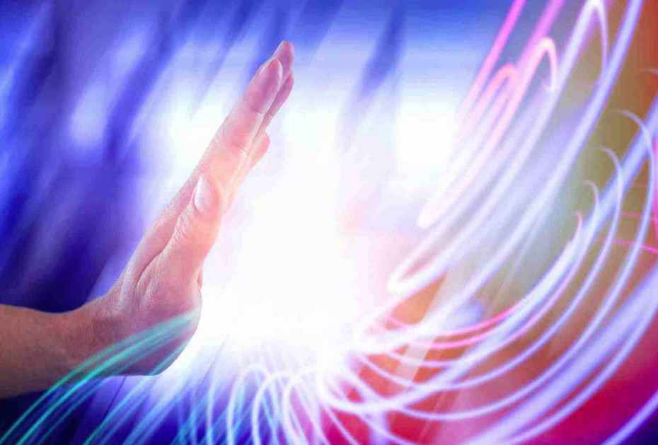 Une main touche la Vibration lumineuse du Soin Quantique de Connexion
